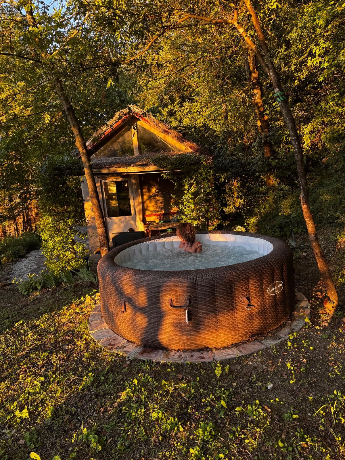 Un jacuzzi con estructura de madera en zona boscosa.