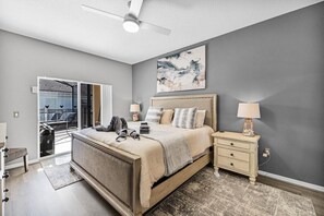Una camera da letto con un letto, comodini, una ventola a soffitto e un'ampia finestra.