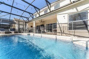 Una piscina con area coperta, lettini e ventilatore a soffitto.