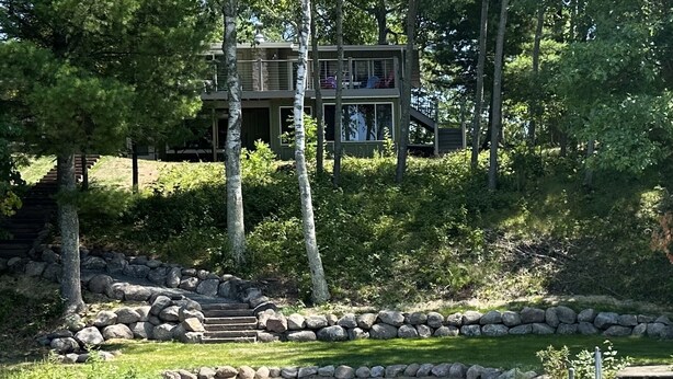 Eine Holzhütte mit Terrasse und einem Kajak am Flussufer.