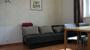 Une pièce comprenant un canapé, une table à manger et des chaises.