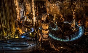 A cave with a glass walkway, surrounded by stalactites and stalagmites. - Windstorm Cabin (Marshall)