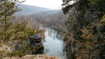 Una valle fluviale con terreno roccioso e vegetazione rada.