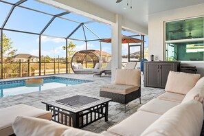 Relax by the pool with a clear view of the surrounding landscape, featuring a rectangular pool, seating area, and a shaded pergola.