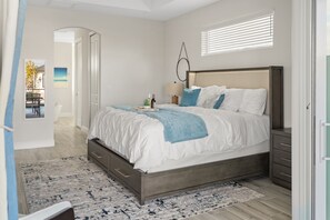 Relax in this serene bedroom with a large bed, nightstand, and a view of the outdoors through a window.