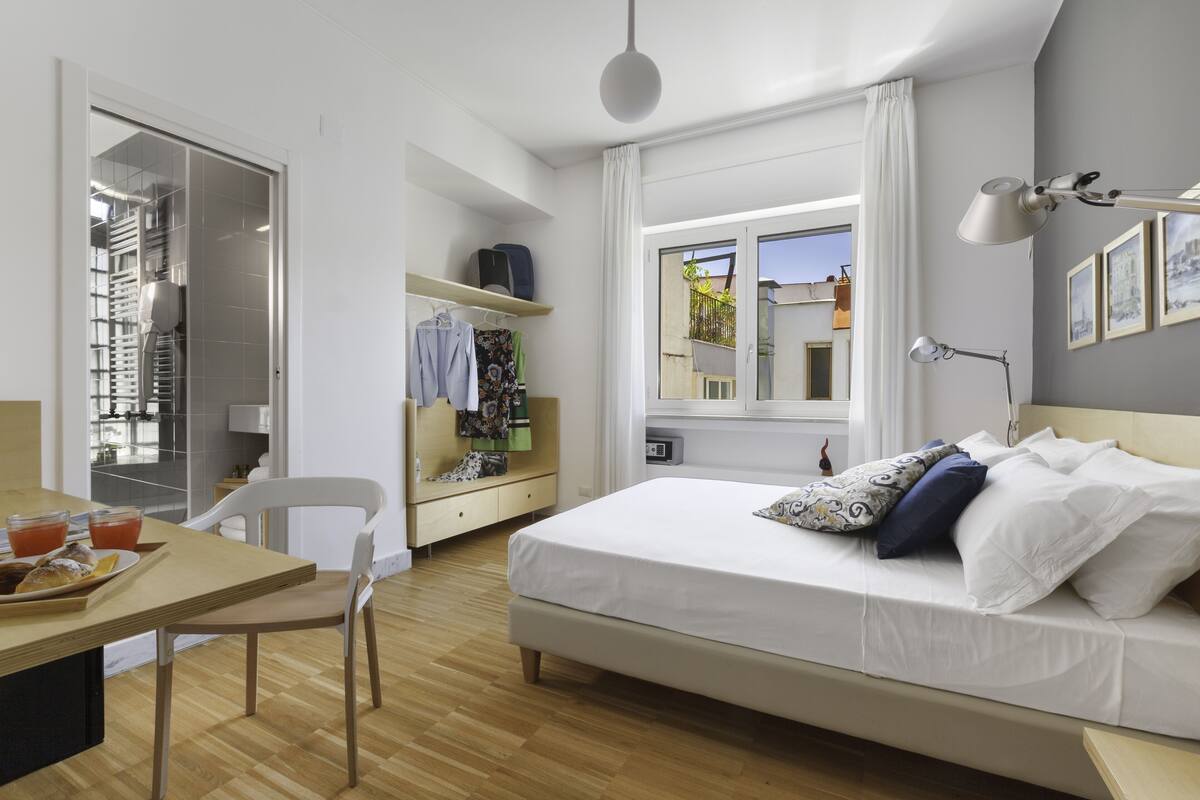 Une chambre à coucher avec un lit, une table de chevet et une fenêtre donnant sur un beau paysage.