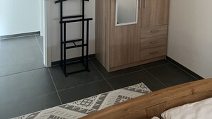 Una camera da letto con un letto, un armadio, una rastrelliera e una porta.