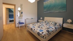 Un dormitorio con cama, escritorio, silla y mesita de noche.