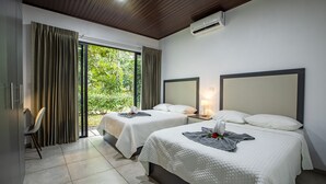 A hotel room with two beds, a desk, and a chair.