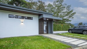 A modern house with a well-maintained lawn, a driveway, and a car parked outside.