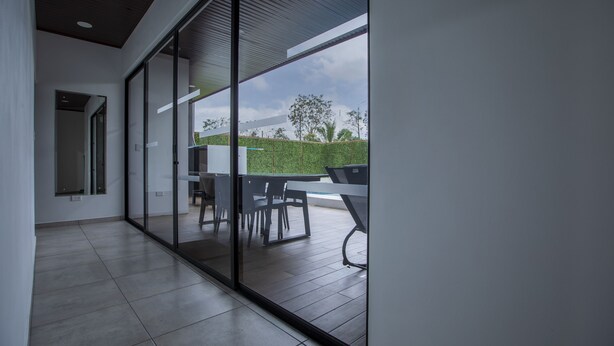 A modern interior with a glass wall leading to an outdoor patio area.
