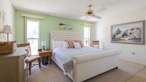 A bedroom with a large bed, a ceiling fan, a desk with a chair, and a window. - Spacious Vacation Home Sun City West 55 Community (Sun City West)