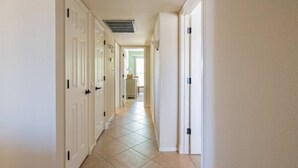 A hallway with white doors and a tiled floor. - Spacious Vacation Home Sun City West 55 Community (Sun City West)