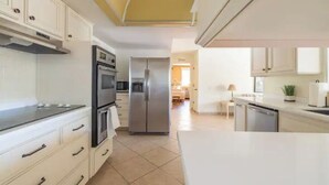 A modern kitchen with white cabinetry, stainless steel appliances, and a large island. - Spacious Vacation Home Sun City West 55 Community (Sun City West)
