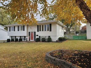 A two-story house with a front door, windows, and a small porch area.