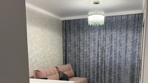 Un salon moderne avec un canapé, une table à manger et un lustre.