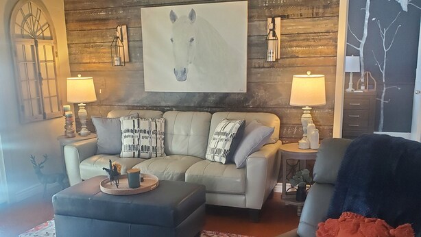 A living room with a sectional sofa, a coffee table, a patterned rug, a fireplace, and a large painting on the wall. - Small Town Foothills Property with Yard (Rye)