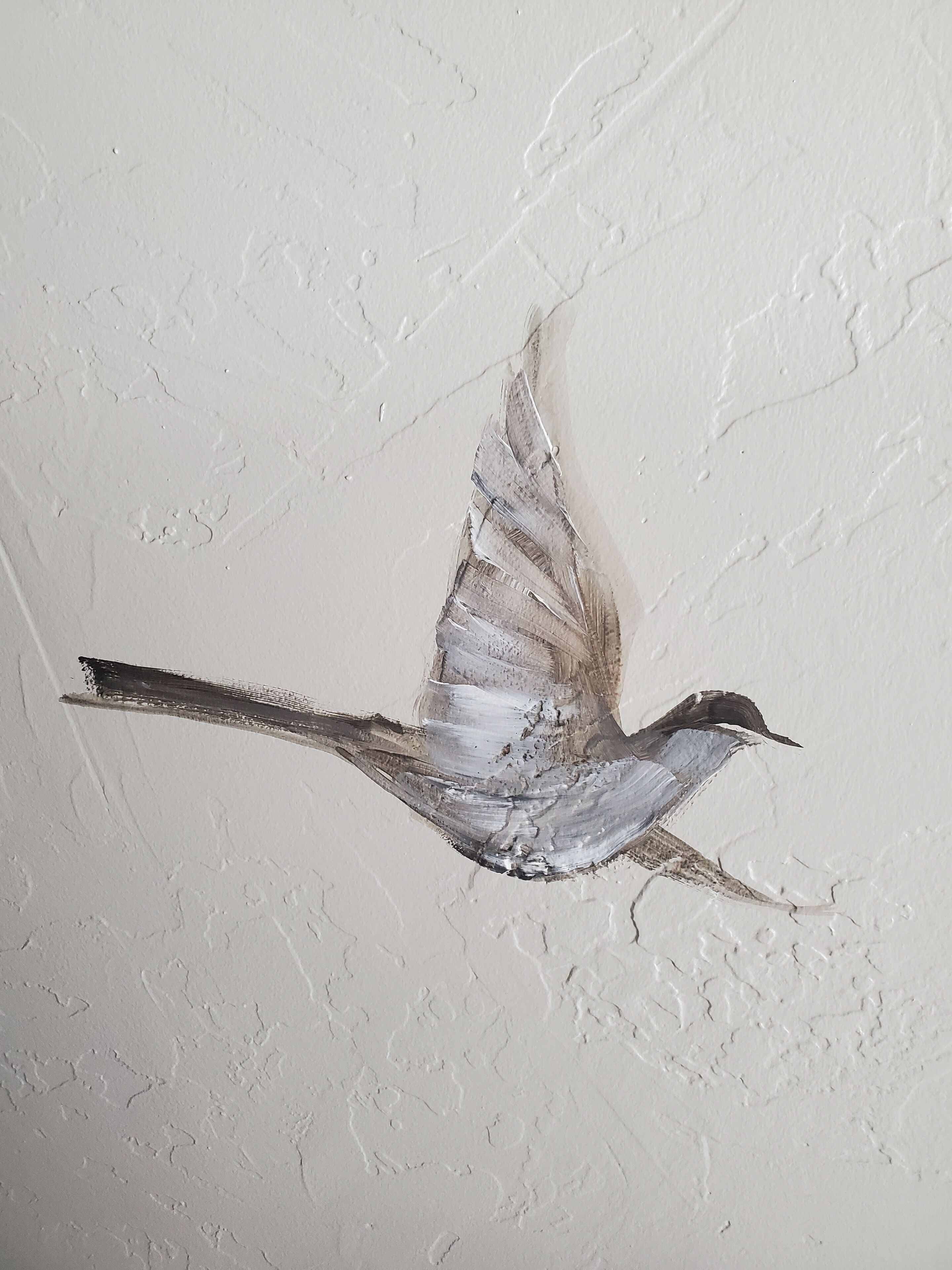 Un mur orné d’une fresque représentant des oiseaux.