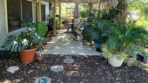 A covered patio with potted plants, a table, and chairs. - Sarasota Cozy & Clean, Near #1 Beach Siesta in SouthGate Neighborhood  (Sarasota)