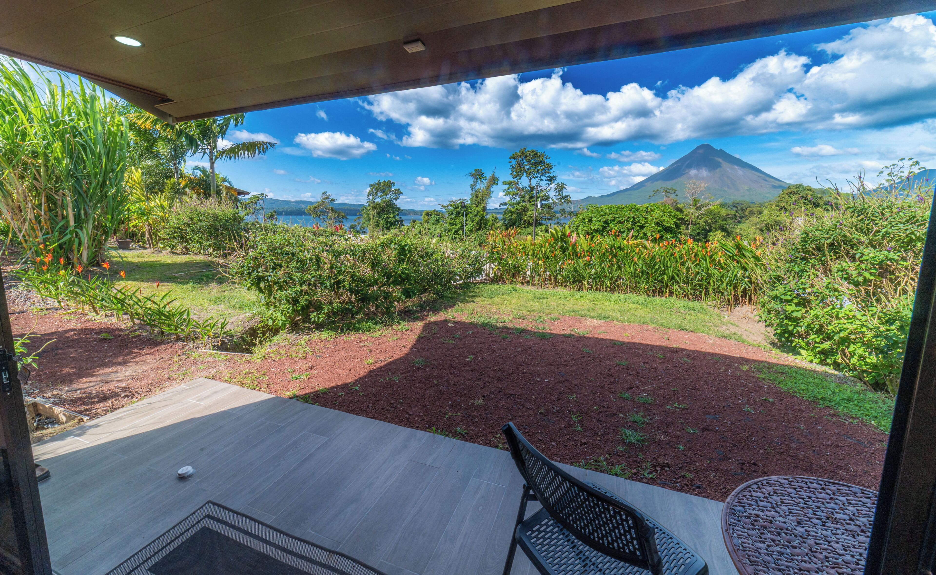 A patio with a view of a mountain and lush greenery.