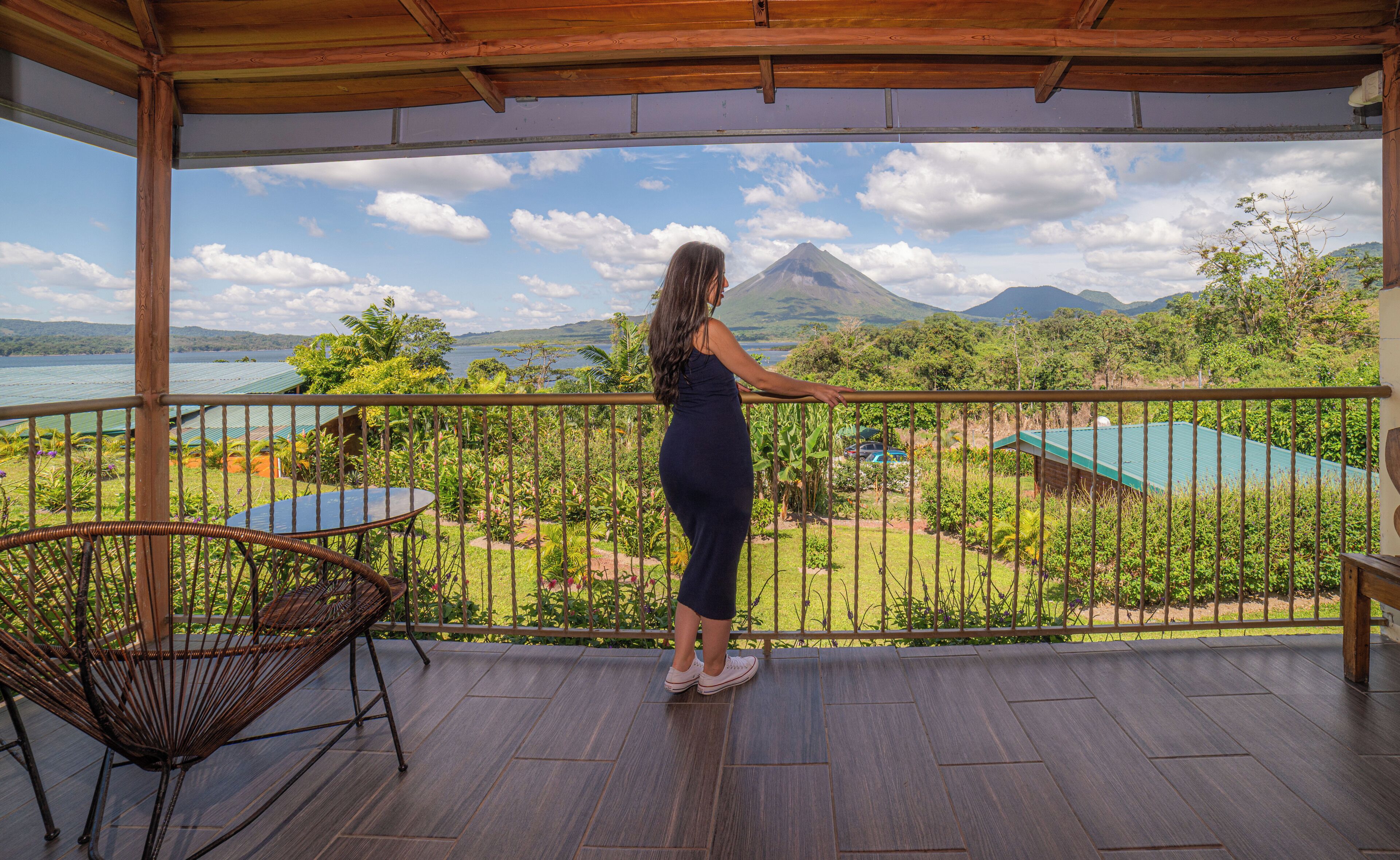 A balcony with a view of a mountain and a body of water.
