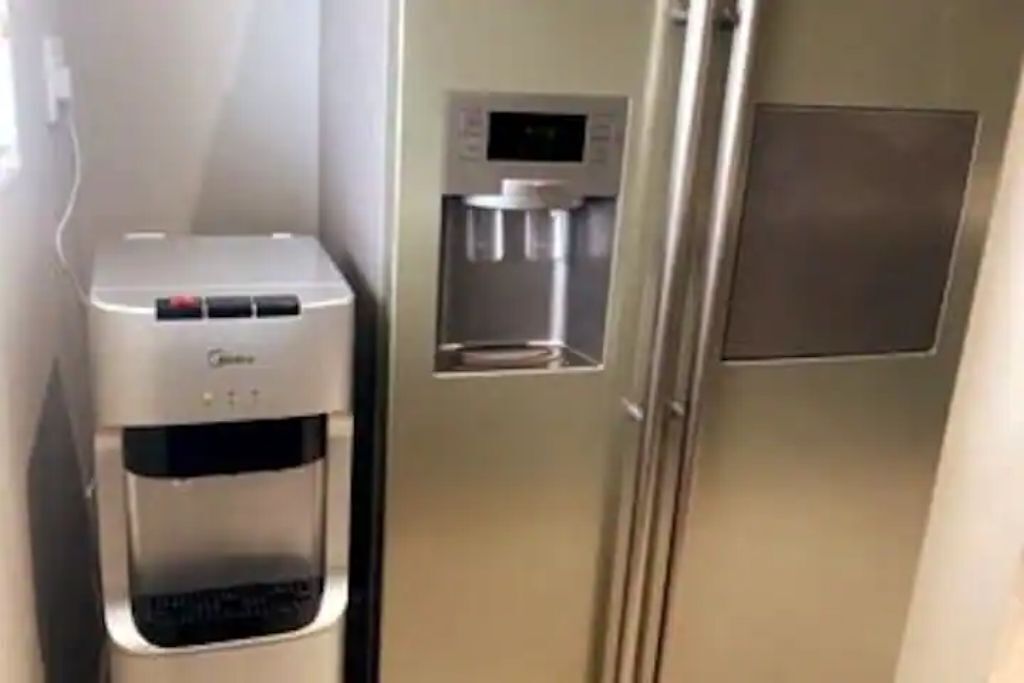 En vattenautomat och ett kylskåp i ett hotellrum.