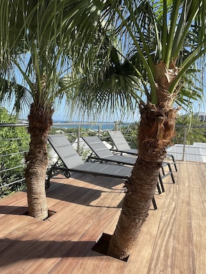 Relax on the ocean-view deck with lounge chairs and a metal railing for a safe and serene experience.
