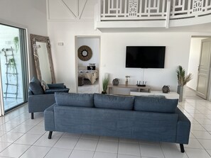 Relax in this stylish living room with a large TV, comfortable sofa, and balcony access.