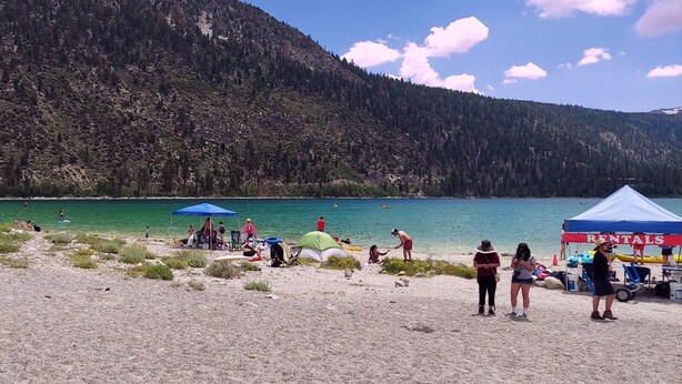 A beach with tents and a rental service. - Cozy Cabin-Style Condo in Central Location (Mammoth Lakes)
