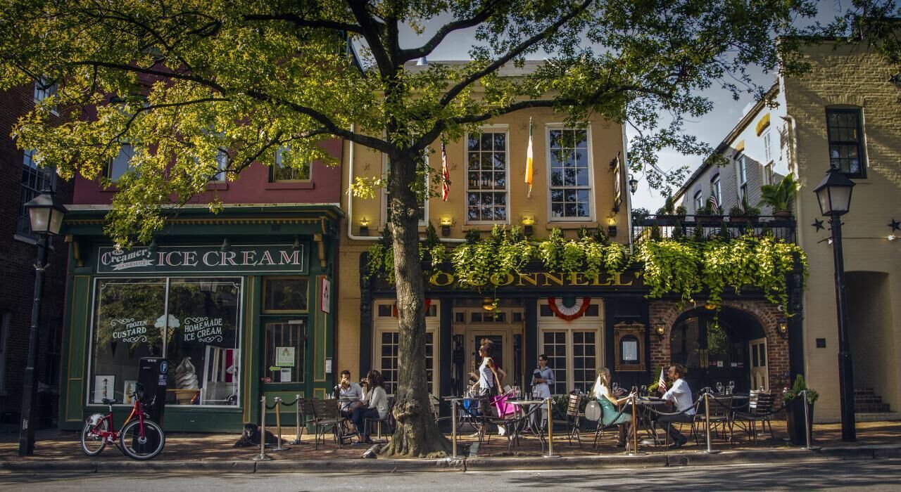 Une scène de rue avec un bâtiment portant l’inscription « Glaces » et un autre avec l’inscription « Ouvert ».