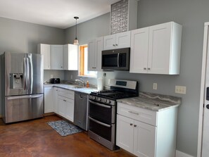 Enjoy cooking and dining in this well-equipped kitchen with a refrigerator, microwave, oven, dishwasher, and gas stove.