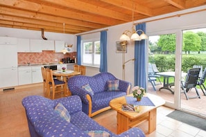 A cozy living room with a sofa set, a coffee table, and a dining area with a table and chairs. - Vacation home in a quiet location, 200m from the nature reserve lake, Mönchshof 13b, with WLAN (Eldetal)