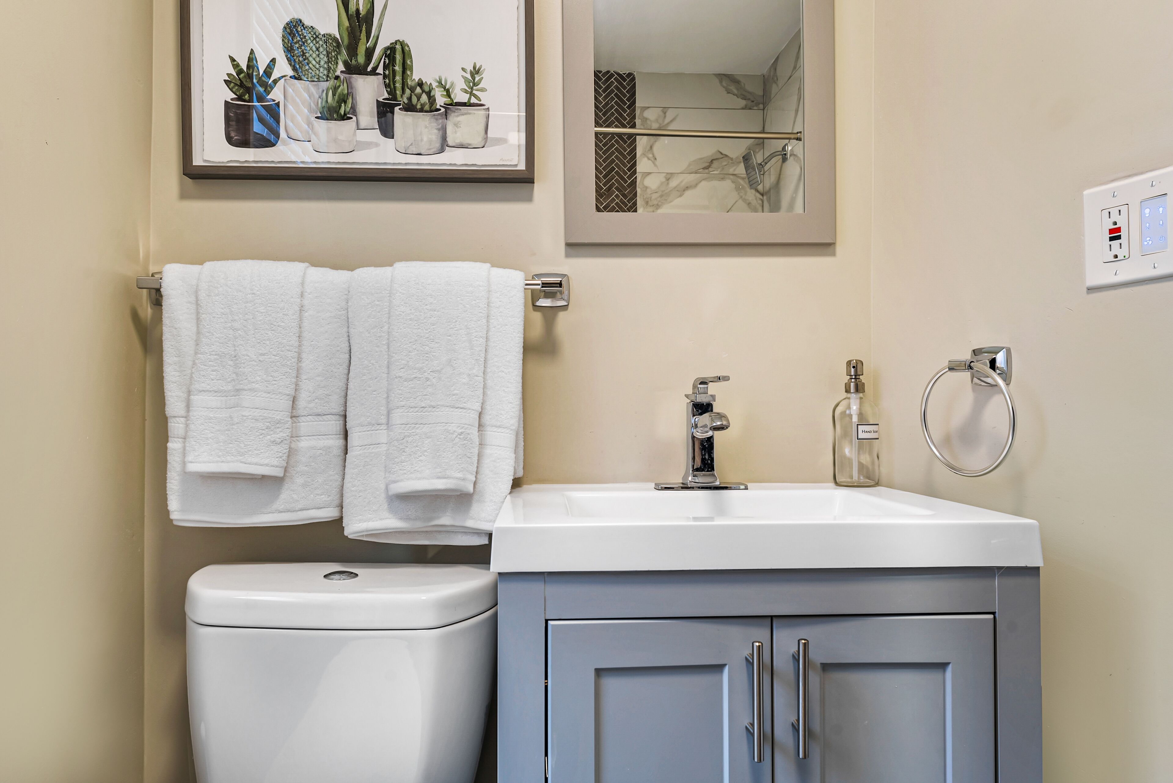 Une salle de bain équipée de toilettes, d’un lavabo et d’un porte-serviettes avec deux serviettes blanches.