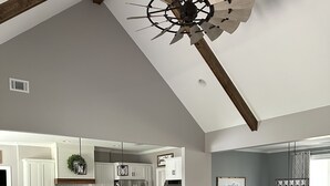 Amplia sala de estar con techo alto, una cocina moderna y un comedor.
