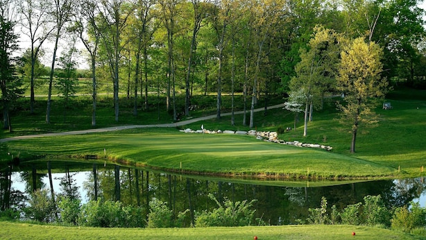A golf course with a pond, surrounded by trees and a walking path. - Four Winds - 1st Floor (Saint Ansgar)