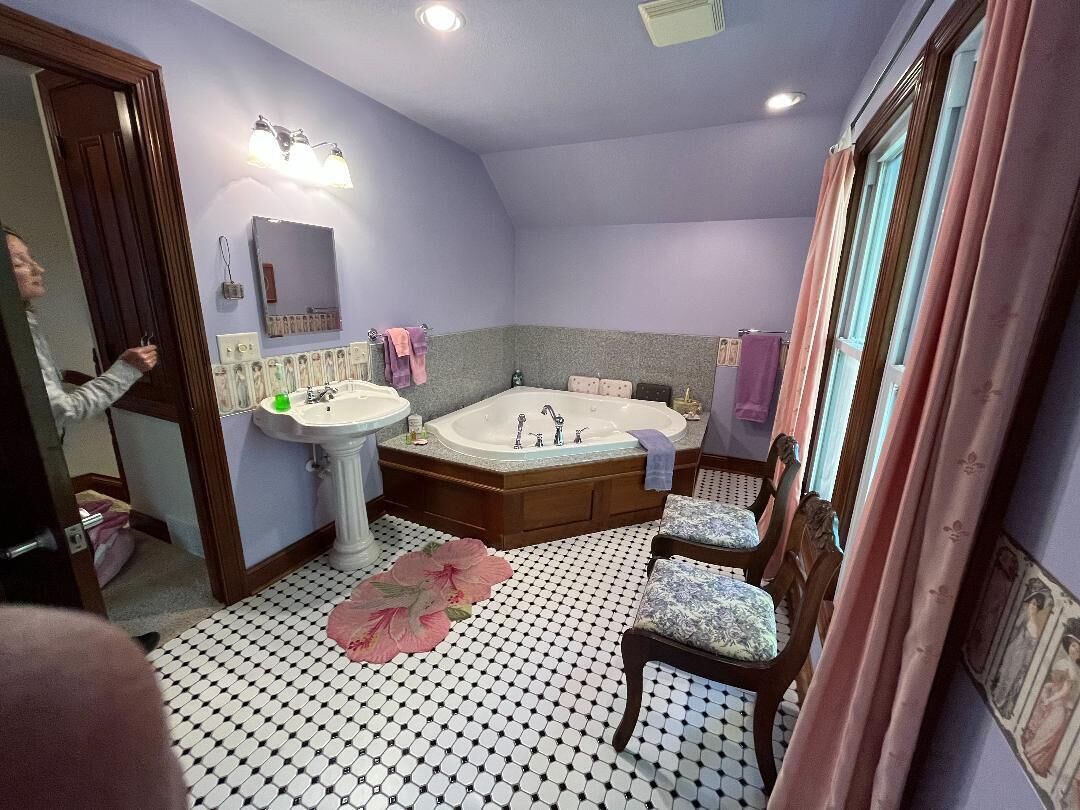 Ein Badezimmer mit einer großen Badewanne, einem Waschbecken und einem Spiegel.