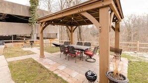 An outdoor patio with a covered seating area, a barbecue grill, and a dining table with chairs. - King & Queen Luxury Memory Foam Beds near Cleveland Airport | Georgetown Villas (Fairview Park)