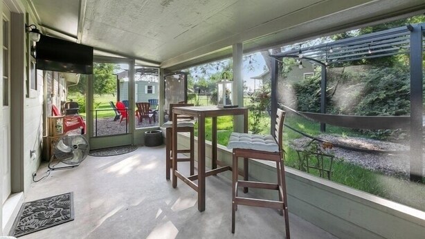 A covered porch with a table and chairs, a fan, and a TV. - 8 Blocks from Main Street (Fredericksburg)
