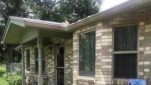A brick building with a covered porch, a small garden with flowers, and a sign that says "THIS IS MY HAPPY PLACE". - 8 Blocks from Main Street (Fredericksburg)