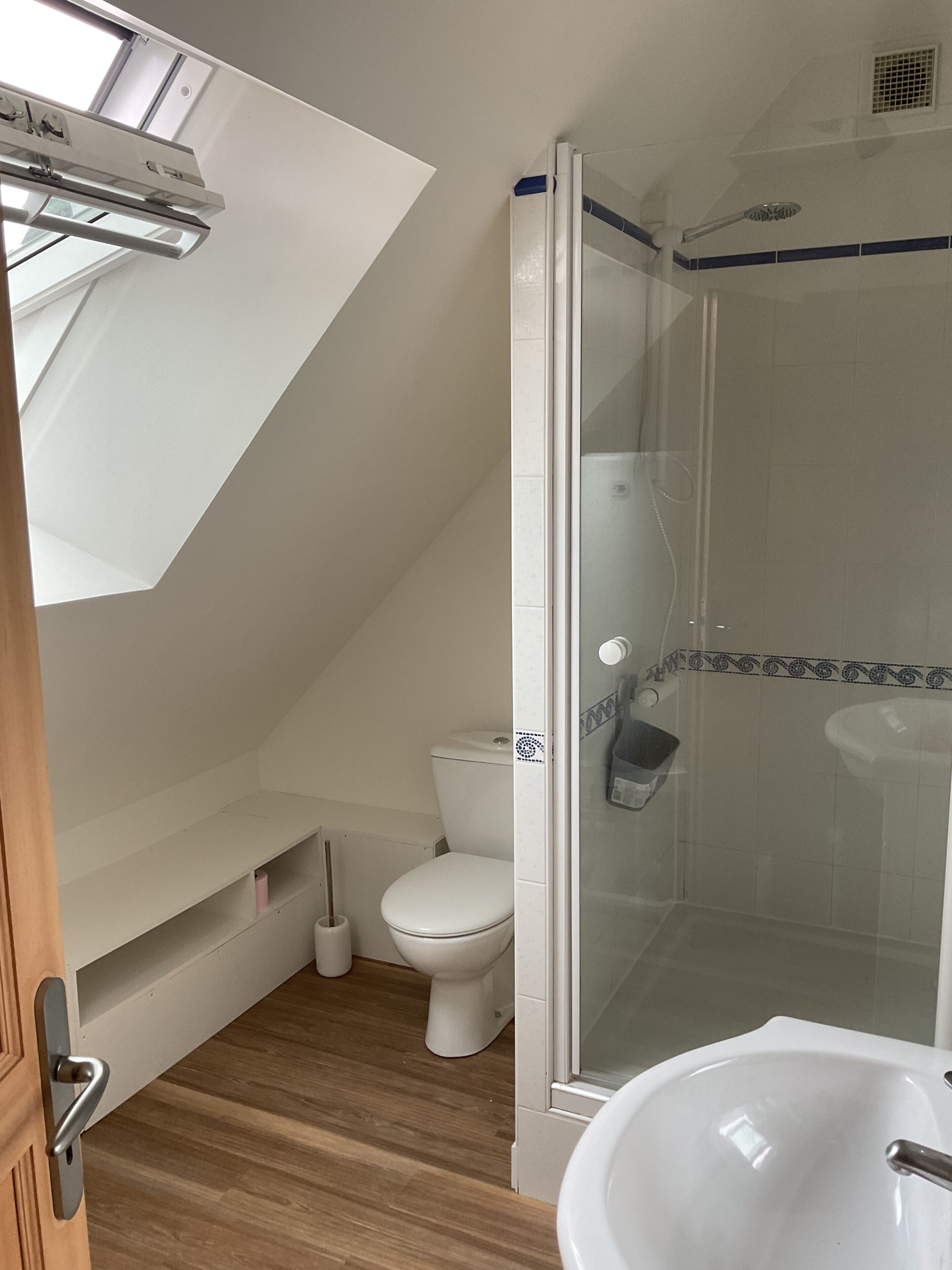Ein modernes Badezimmer mit einer Duschkabine, einer weißen Toilette und einem Waschbecken.