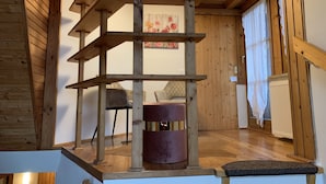 Un interior de madera con una estructura central de madera, un radiador y una silla.