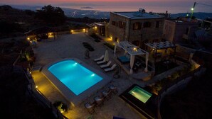 Un espace piscine comprenant une piscine rectangulaire, des chaises longues et une pergola.