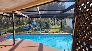 Una piscina techada con vistas a un jardín y una estatua.