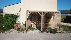 Un bâtiment doté d’une grande entrée, d’une antenne parabolique et de plantes en pot.