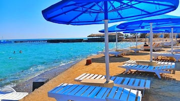 Playa privada, playa de arena blanca, sombrillas y toallas de playa