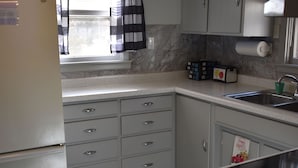 A kitchen with a refrigerator, a sink, and cabinets. - Cozy Nothwoods home next to ATV/Snowmobile trails (Laona)