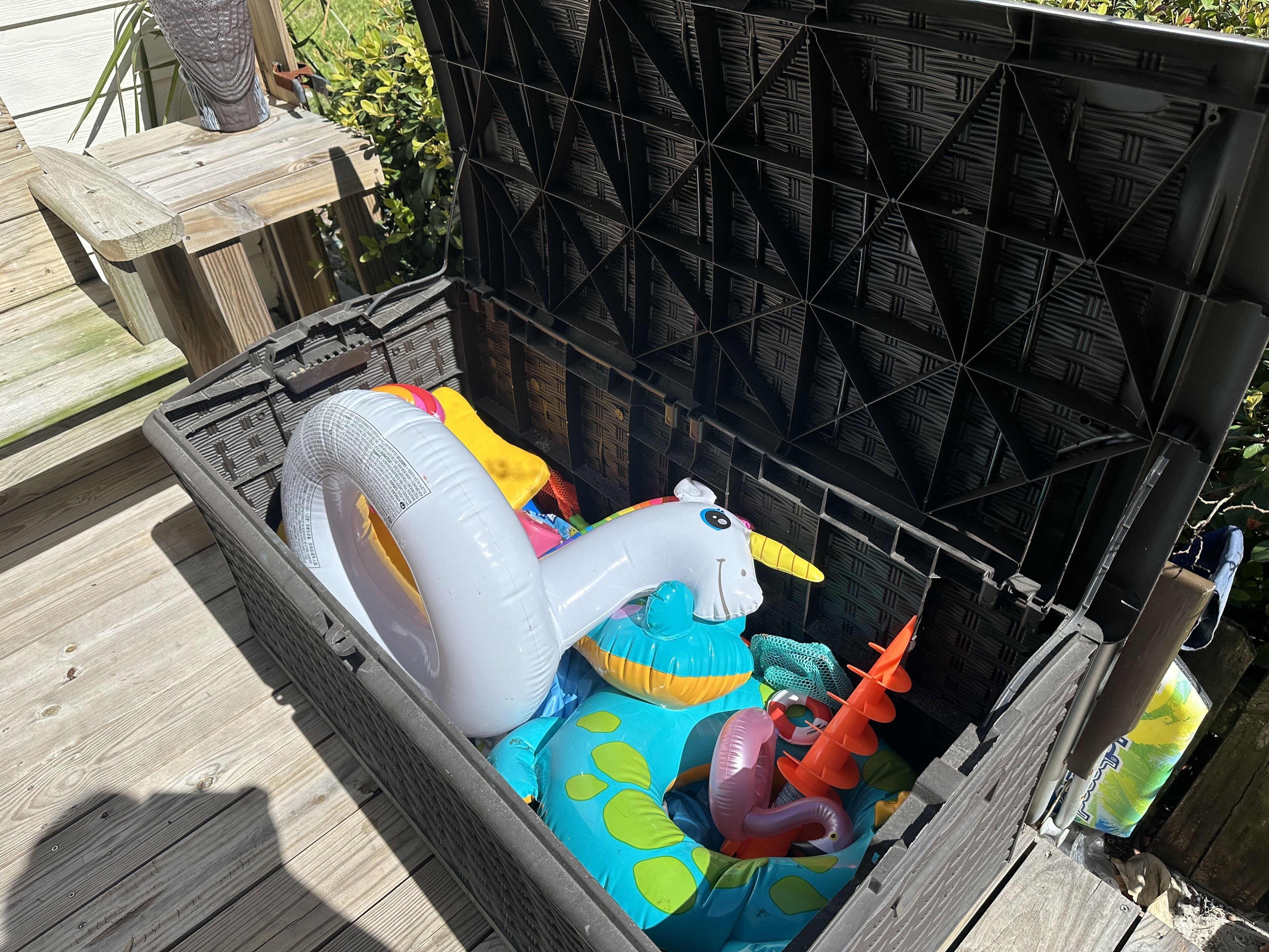 Una caja de almacenamiento con juguetes inflables para piscina.