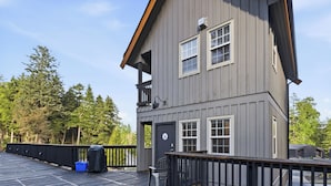 A two-story building with a balcony, a door with a logo, and a window with a grid pattern. - Steps from the Beach! ~ Near Wild Pacific Trail! ⎮ Orca (Ucluelet)