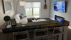 Une cuisine moderne avec un coin bar, une guitare et un téléviseur diffusant des images du monde sous-marin.