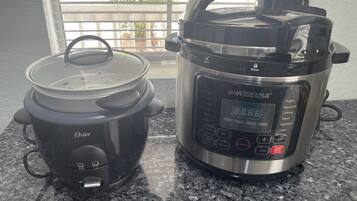 Una olla de cocción lenta GoWISEUSA y una olla de cocción lenta Oster sobre una encimera de granito.
